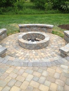 an outdoor fire pit surrounded by bricks