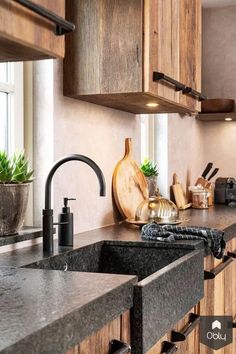 a kitchen with wooden cabinets and black granite counter tops, along with a large sink