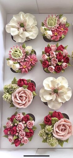 a box filled with lots of different types of flowers on top of a white surface