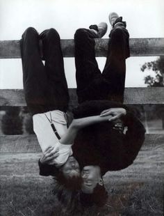 two people are upside down on the ground with their hands in each other's pockets