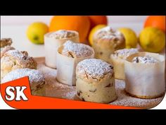 several pastries on a table with oranges in the background