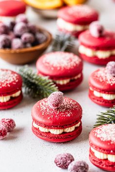 red velvet macaroons with powdered sugar on them and pine cones in the background