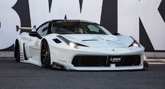 a white sports car parked in front of a wall