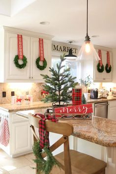 a kitchen decorated for christmas with wreaths on the counter and decorations hanging from the ceiling