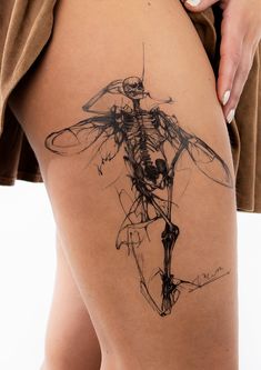 a woman's thigh with a skeleton tattoo on it