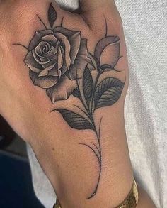 a black and white rose tattoo on the left hand