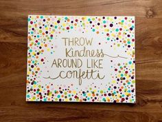 a card that says, throw kindness around like confetti on top of a wooden table