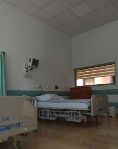 an empty hospital room with two beds in it