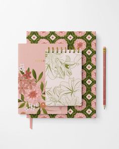 a notebook with pink flowers and green leaves