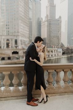 a man and woman standing next to each other in front of a cityscape