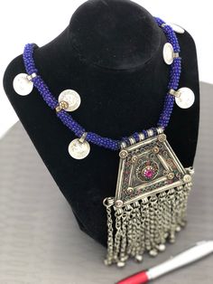 * This handmade Afghani Kuchi style Necklace is a magnificent piece of art as it carries all the elements which make this ethnic ornament authentic traditional wear. * This necklace has intricately carved designs and multicolor stones carved into the pendent making the ornament more ravishing and tempting. * The lower part of the artifact has been embellished with silver dangling beads connected to the pendant with long chains. Not only that the blue beads rolled around the thread has complement Traditional Beaded Festival Jewelry, Beaded Necklaces For Festive Rituals, Festive Beaded Necklaces For Rituals, Festive Ritual Beaded Necklaces, Festive Ritual Beaded Necklace, Traditional Beaded Jewelry For Festival, Beaded Pendant Jewelry For Festivals, Festive Beaded Pendant Jewelry, Traditional Beaded Chain Jewelry For Festivals