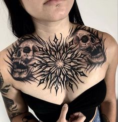 a woman with tattoos on her chest and two skulls in the middle of her chest