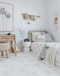 a bed room with a neatly made bed next to a wooden desk and two pictures on the wall