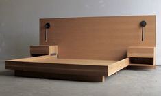 a bed with two nightstands on each side and a headboard made out of wood