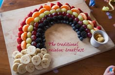 a wooden cutting board topped with fruit and veggies