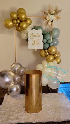 a table topped with balloons and a gold cup