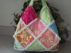 a multicolored purse sitting next to a potted plant