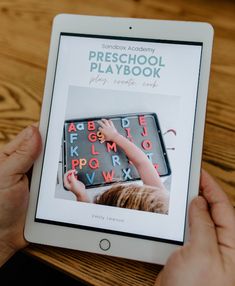 someone is holding an ipad with the book preschool playbook on it