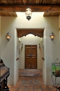 an entry way with a wooden door and light fixtures