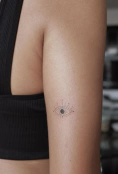 a woman's arm with an eye tattoo on the left side of her arm