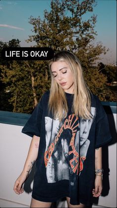 a woman with her eyes closed standing in front of a tree and the words life is okay