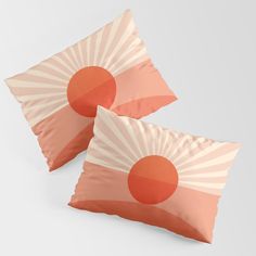 two orange and white pillows with sunbursts on them