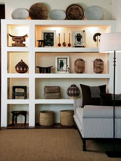 a living room filled with lots of furniture next to a white book shelf covered in pictures