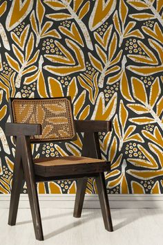 a chair sitting in front of a wall with an orange and white pattern on it