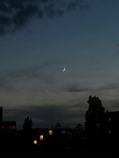 the moon is shining in the sky over some buildings