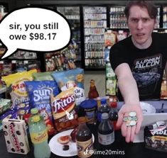 a man standing in front of a table filled with snacks and confection items