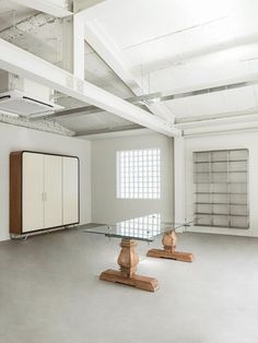 an empty room with two glass tables in the middle and shelves on the other side