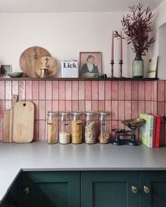 the kitchen counter is covered with jars, spices and utensils on it's shelf