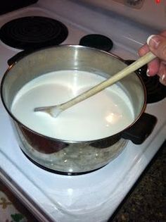 a person stirring milk in a pot on the stove