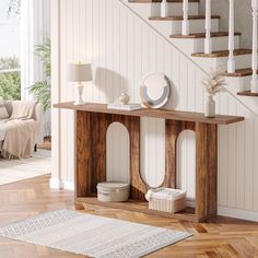 a wooden table sitting on top of a hard wood floor next to a stair case