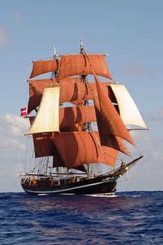 an old sailing ship in the middle of the ocean