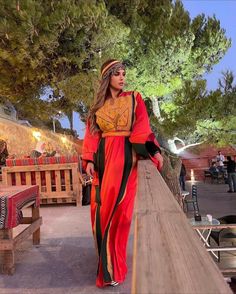 a woman standing on top of a wooden bridge