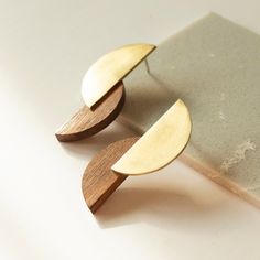 Brass and Wood Statement Earrings: Bauhaus Art inspired   Jewelryfor her This contemporary earrings are a design inspired by the avant-garde of the Bauhaus, specifically, in the work of the artist Lazslo Moholy Nagy. Geometry and abstraction are the perfect concept for minimalist and simple jewelry design.  The earrings consists of two circle segments, one made of matte brass, and the other made of Pao Ferro wood. The union of the two pieces is made with two small rivets so that the pieces canno Simple Jewellery Designs, Architect Gift, Gift For Architect, Avant Garde Jewelry, Moholy Nagy, Wood Earrings Stud, Bauhaus Art, Contemporary Earrings, Art Earrings