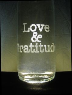 a clear glass with the words love and gratitud written in white on it