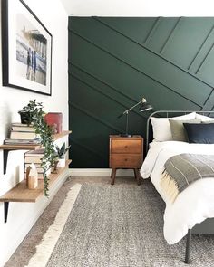 a bedroom with dark green walls and white bedding