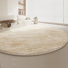 a living room with a white couch and large rug on the floor in front of a window