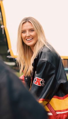 a woman with blonde hair wearing a black leather jacket