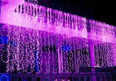 purple christmas lights on the side of a building at night with text overlaying it