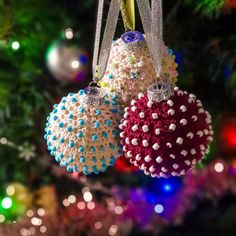 two ornaments are hanging from a christmas tree