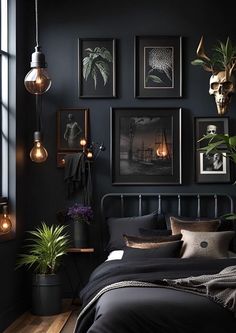 a bedroom with black walls and pictures on the wall above the bed, along with potted plants