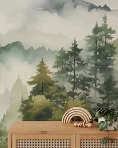 a wooden cabinet sitting in front of a wall mural with trees and mountains on it