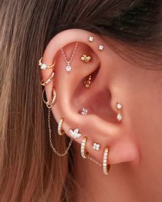 a woman wearing multiple ear piercings with flowers on them