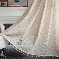 a white chair sitting next to a window covered in a blanket