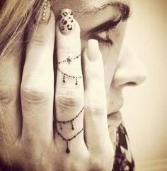 a woman's hand with two fingers and a cross tattoo on the middle finger