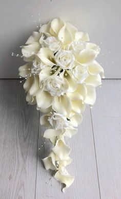 a bouquet of white flowers sitting on top of a wooden floor