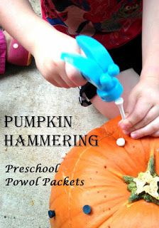 a young child is decorating a pumpkin with blue plastic handles and sprinkles